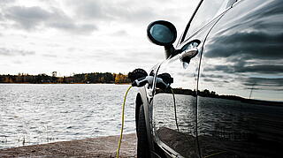 E-Auto wird vor einem See geladen